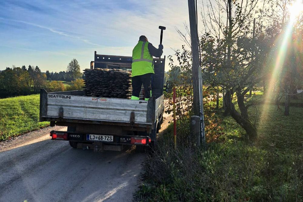 Polnjenje steklenice z vodo v kuhinji s sadjem na pultu